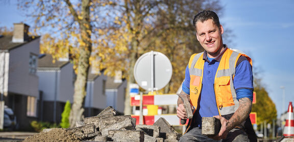 Medewerker gemeente Best werkzaam aan straat