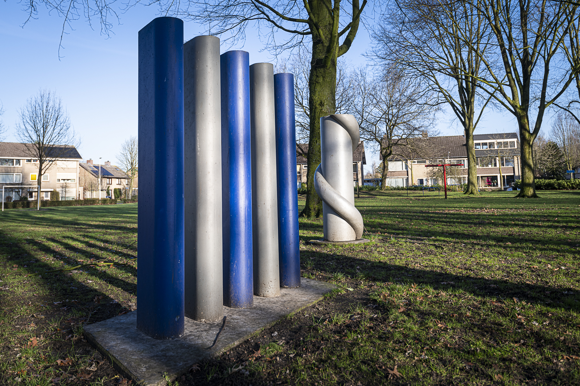 Kunstwerk met 5 blauwe en grijze zuilen en helix